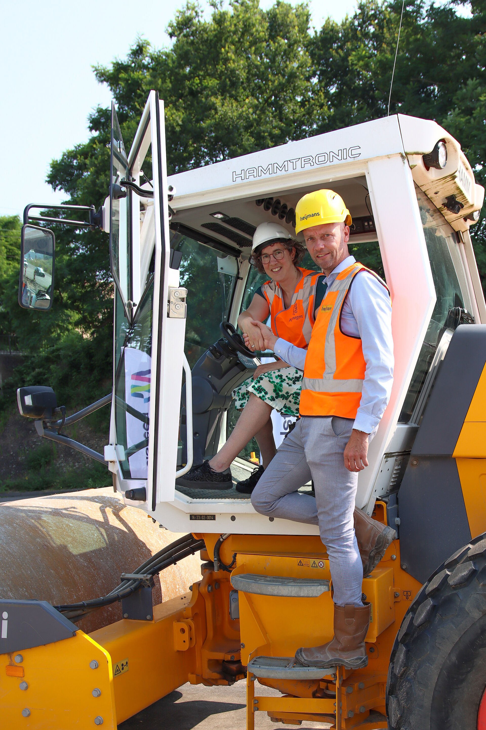 Een foto van wethouder Cilia die de hand schud van een partner van de gemeente tijdens de opening van een nieuw stuk weg in Winkelsteeg