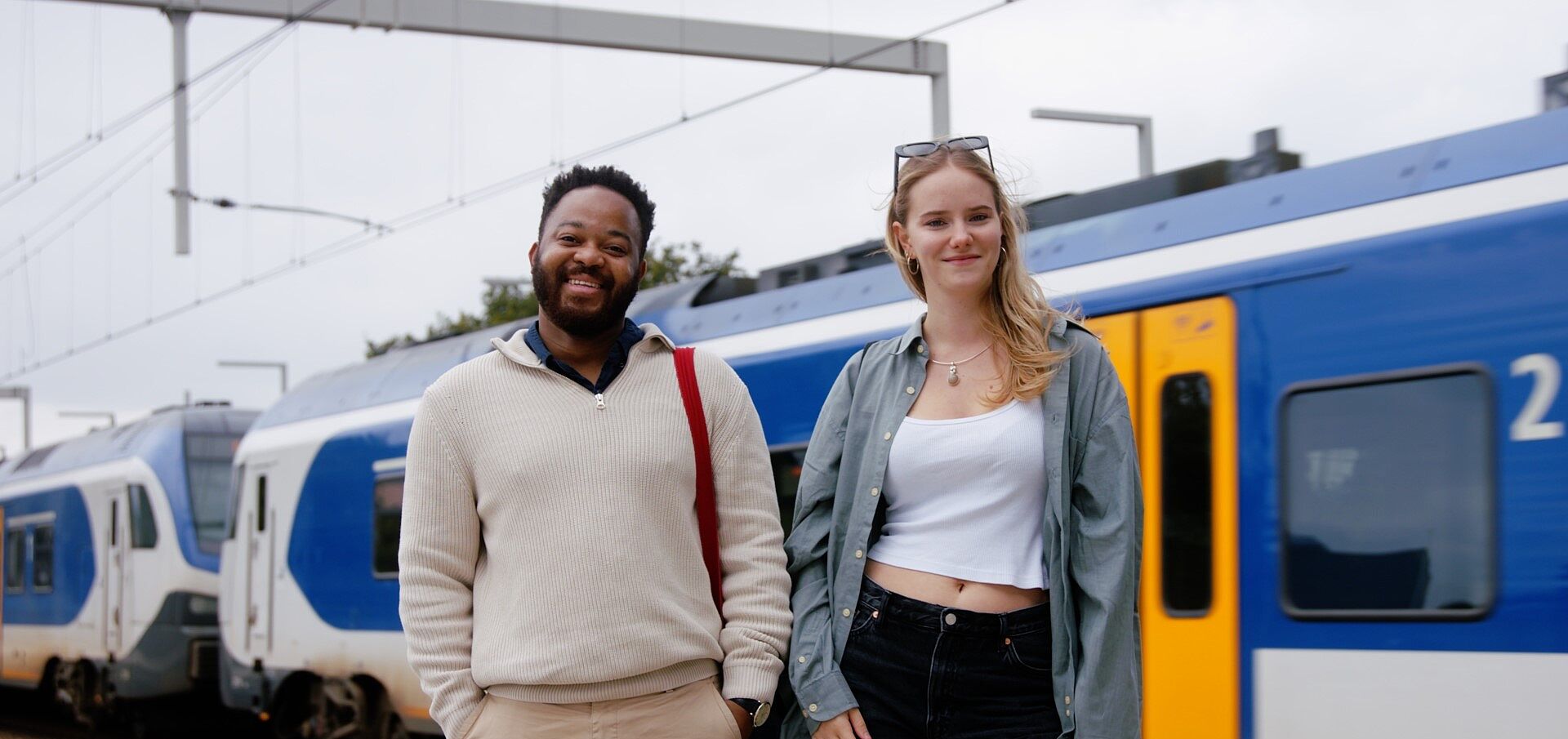 Twee jongeren die voor een trein staan.