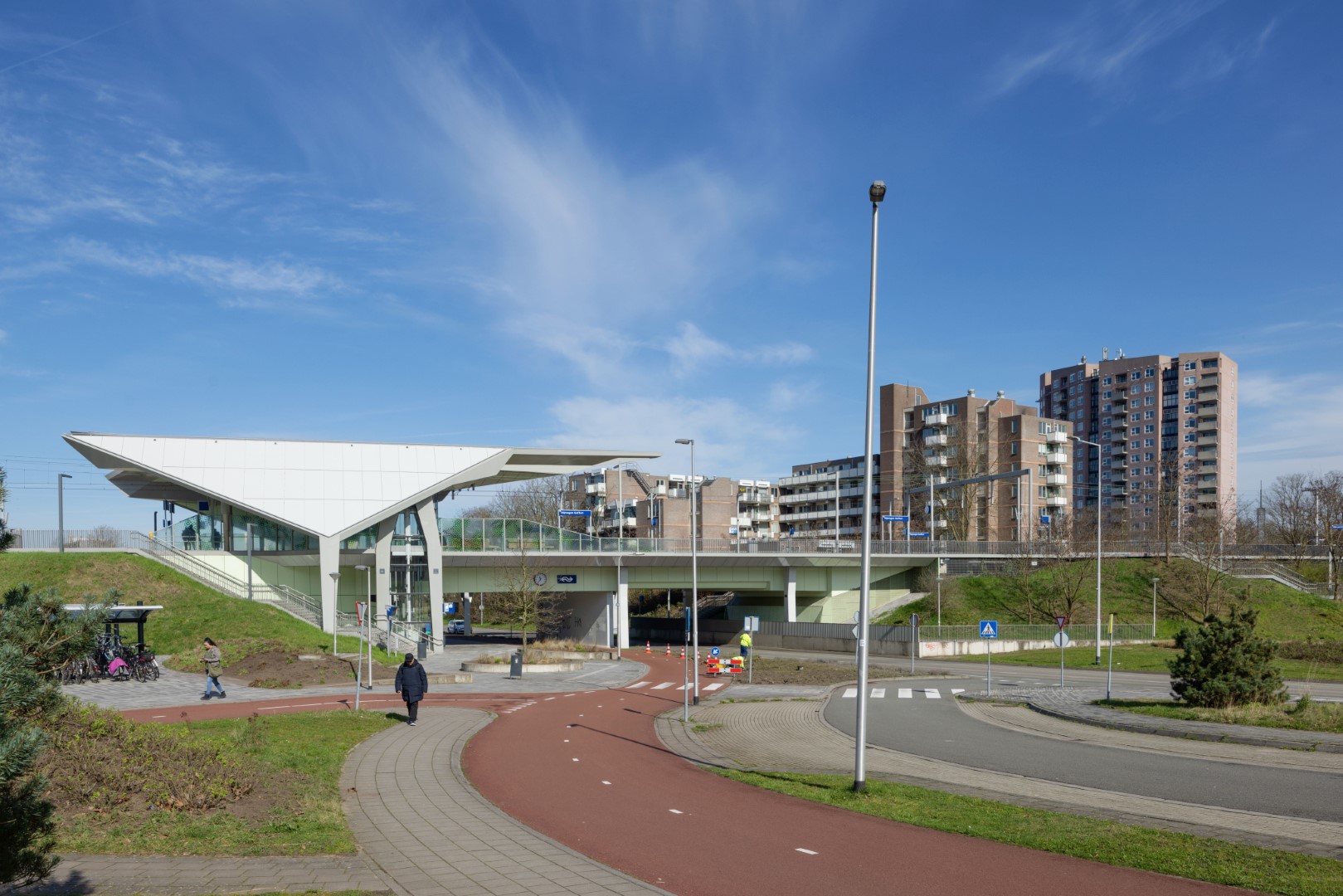 Een foto van een fietspad, een weg en treinstation Goffert